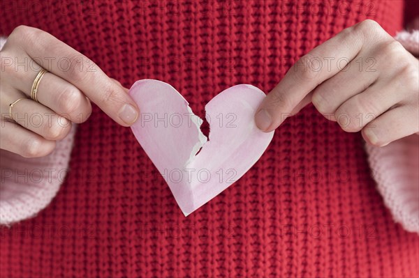 Woman ripping paper heart in half