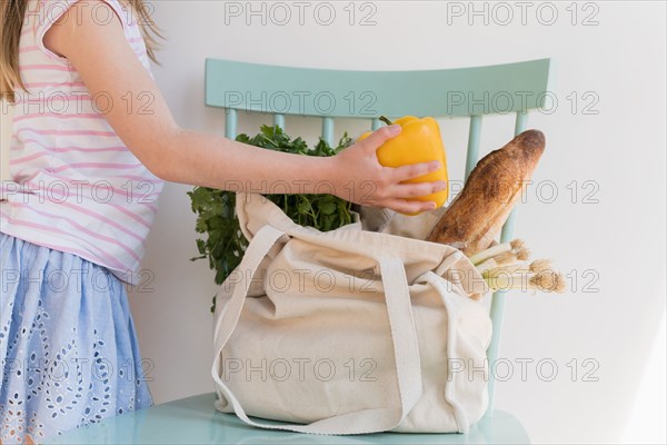 Girl unpacking products from reusable bag