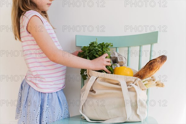Girl unpacking products from reusable bag