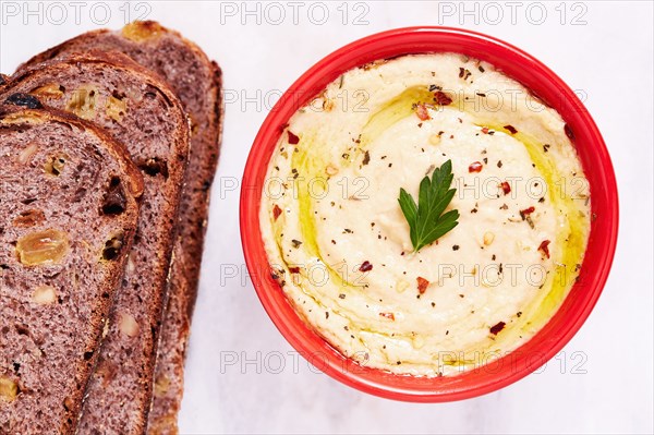 Overhead view of bowl of hummus and slices of bread