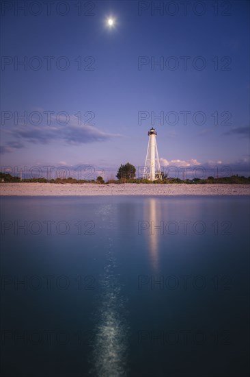 USA, Florida, Boca GrandeLighthouse reflecting in sea at night