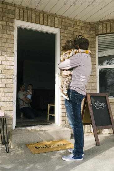 Father with daughter (2-3) visiting friends while keeping distance