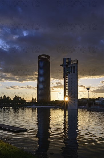 Spain, Seville, Guadalquivir River, Office blocks and Guadalquivir River at sunset