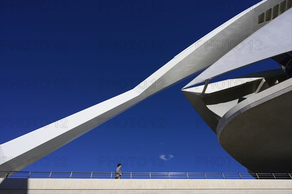 Spain, Valencia, Woman walking by Palau De Les Arts Reina Sofia opera house