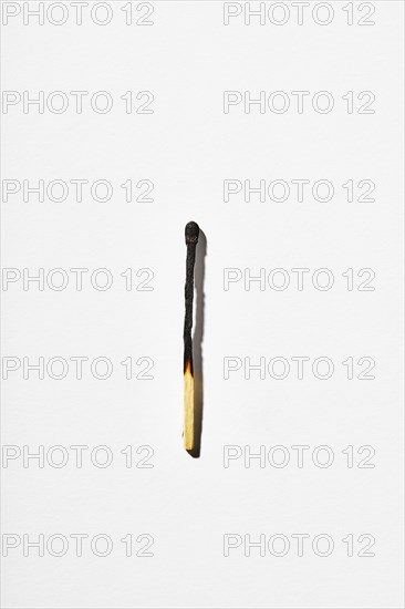 Burnt matchstick on white background