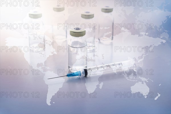 Vials and syringe with world map in background