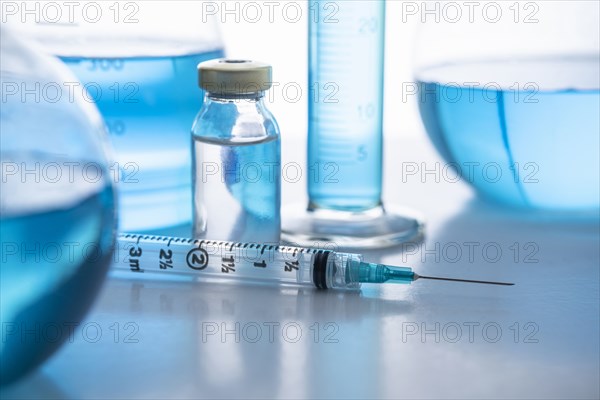 Laboratory glassware with liquid and syringe