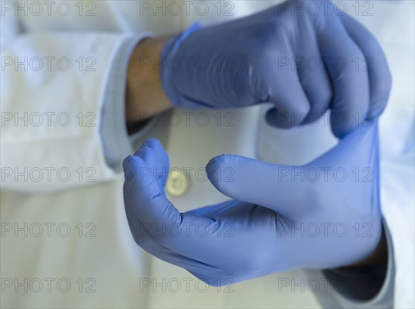 Close-up of doctor putting on blue latex gloves