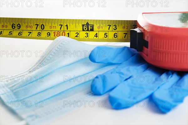 Studio shot of tape measure, surgical mask and gloves