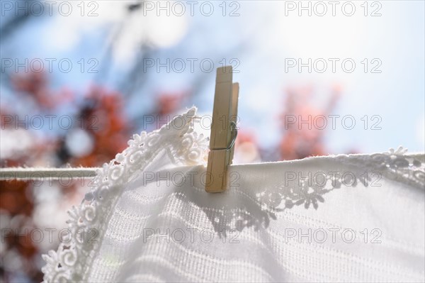 White tablecloth drying on clothesline in sunlight