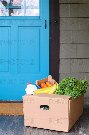 Box of delivered produce on house porch