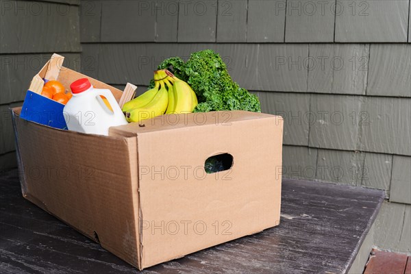 Box of delivered produce on house porch