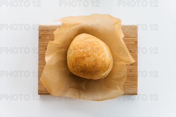 Fresh loaf of bread cooling on cutting board