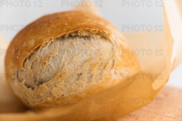 Fresh loaf of bread cooling on cutting board