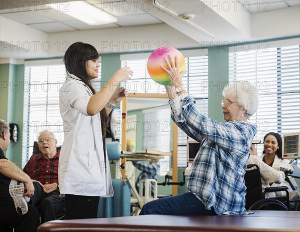 Senior woman exercising with therapist during physical therapy