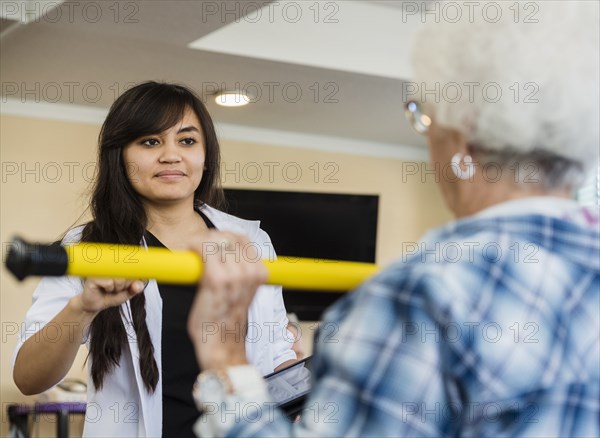 Senior woman exercising with therapist during physical therapy