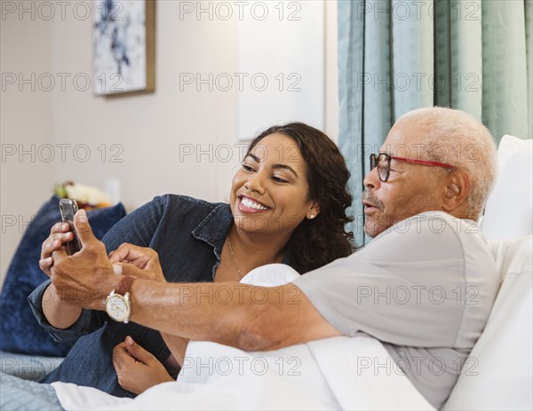 Father and daughter taking selfie in nursing home