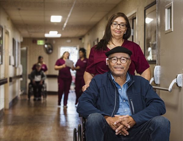 Nurse assisting senior man in wheelchair