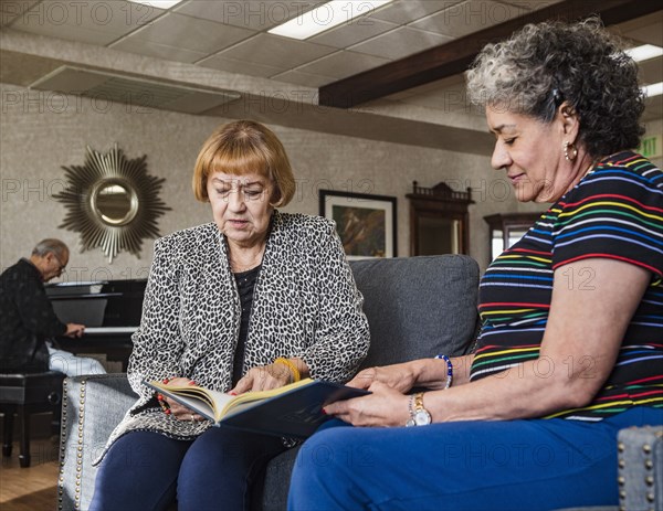 Senior women looking at album