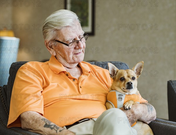 Senior man holding service dog