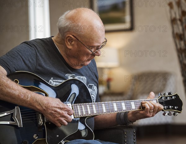 Senior man playing guitar