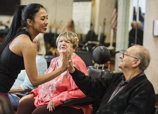 Senior man high-fiving fitness instructor