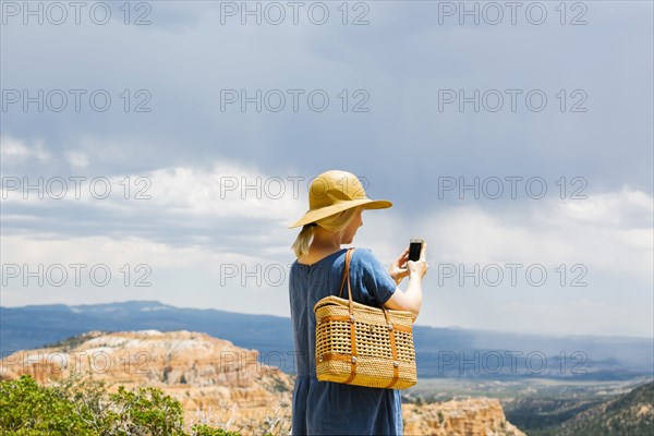 USA, Utah, Bryce Canyon, Woman photographing canyon with smart phone