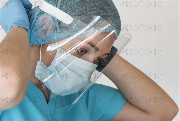 Nurse putting on face shield