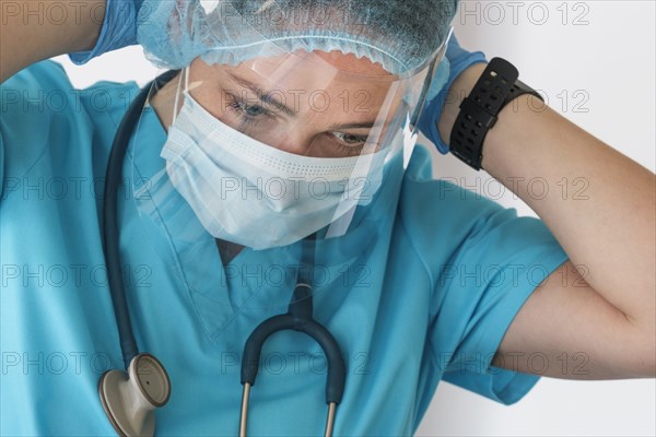 Nurse putting on face shield