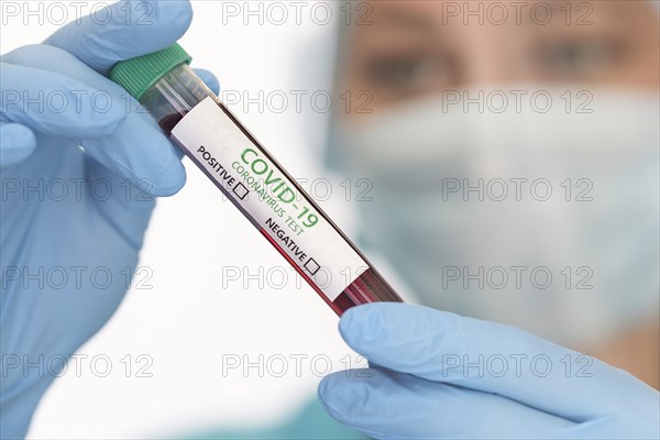 Close-up of doctors hands holding Covid-19 test sample