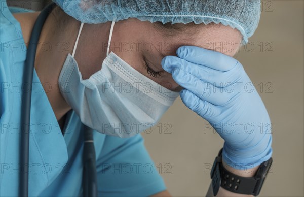 Nurse in face mask experiencing symptoms