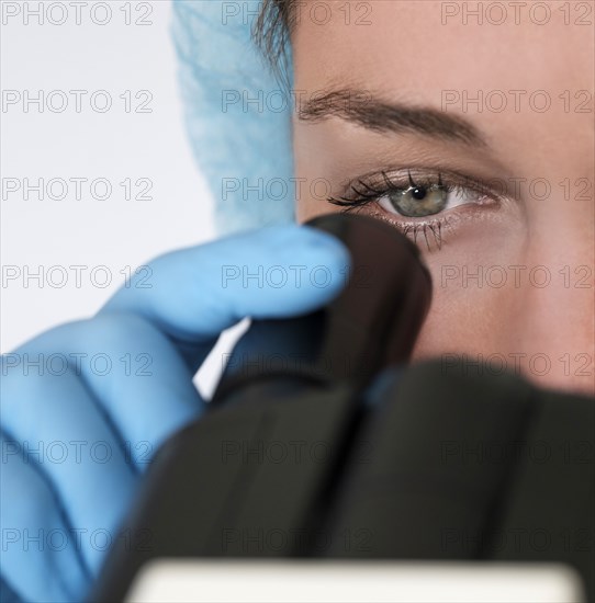 Laboratory technician looking through microscope