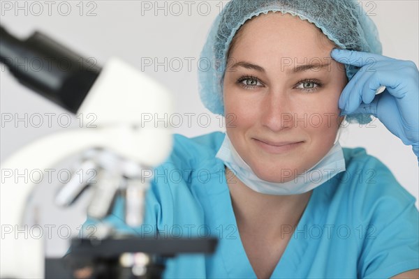 Portrait of laboratory technician next to microscope