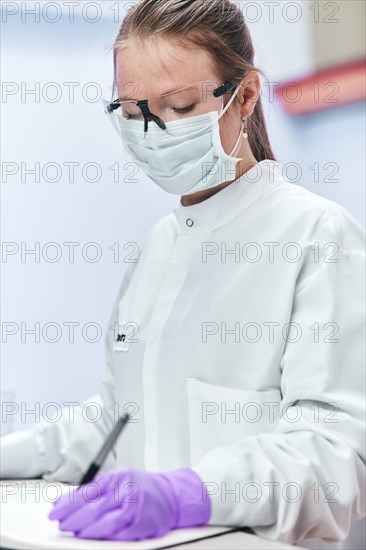 Female technician writing in notebook