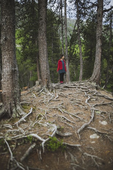 Switzerland, Bravuogn, Palpuognasee, Young woman standing in forest