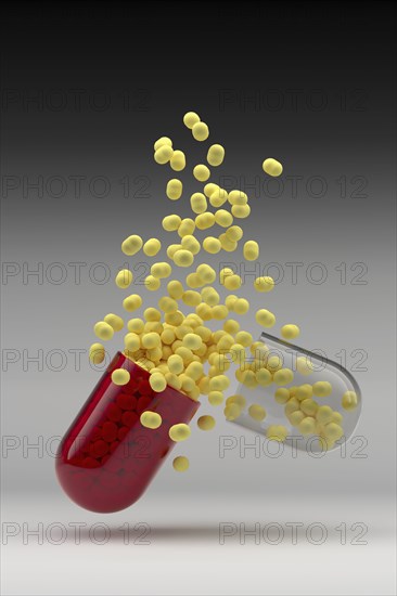 Studio shot of capsule with yellow pills inside