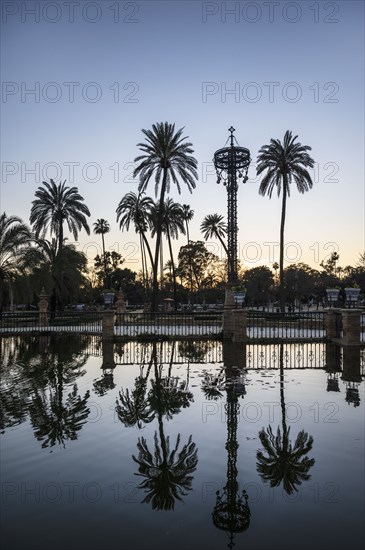 Spain, Seville, Palm trees reflecting in water at Plaza de America
