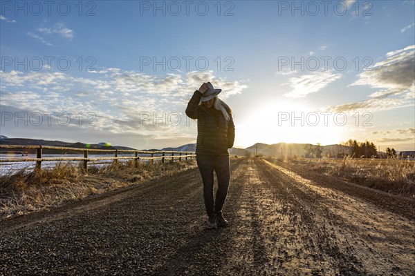USA, Idaho, Sun Valley, Woman at sunrise on rural road