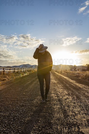 USA, Idaho, Sun Valley, Woman at sunrise on rural road