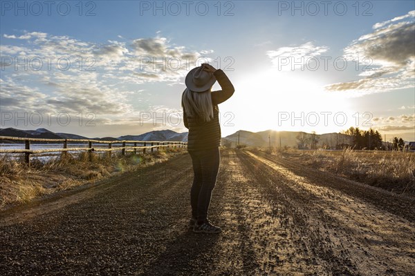 USA, Idaho, Sun Valley, Woman at sunrise on rural road