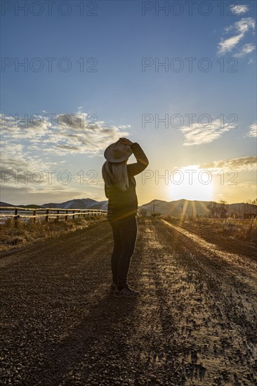 USA, Idaho, Sun Valley, Woman at sunrise on rural road