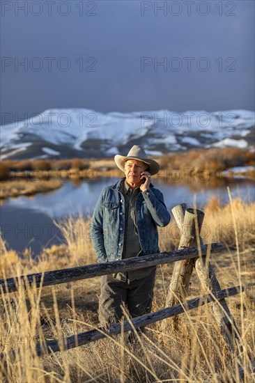 USA, Idaho, Sun Valley, Senior man in cowboy using smartphone