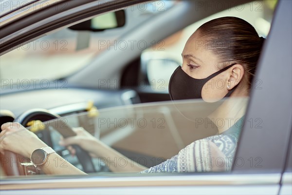 Woman with face mask driving car