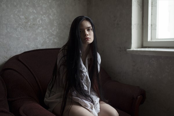 Portrait of young woman sitting in armchair