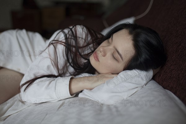 Young woman lying on bed