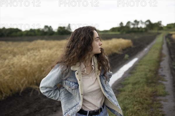 Russia, Omsk, Young woman standing in field