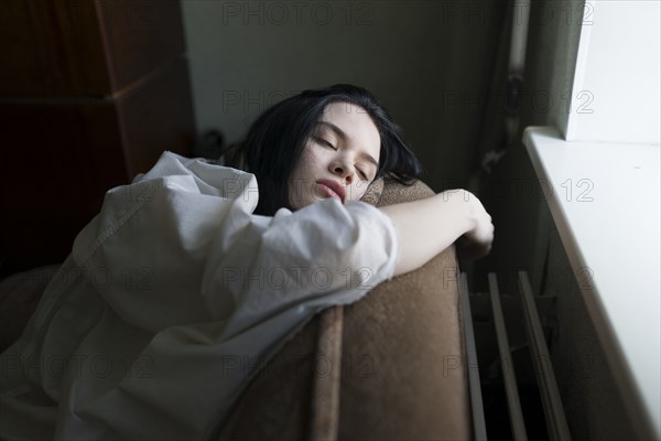 Young woman leaning by window