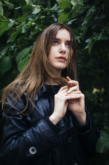 Portrait of young woman standing by tree