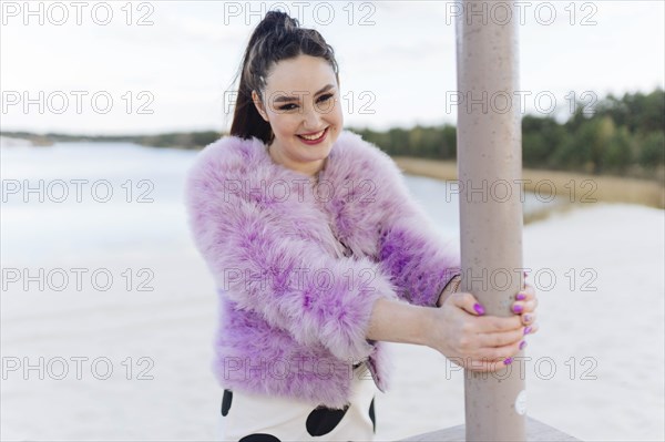 Belarus, Minsk, Portrait of young woman in pink cur coat on beach