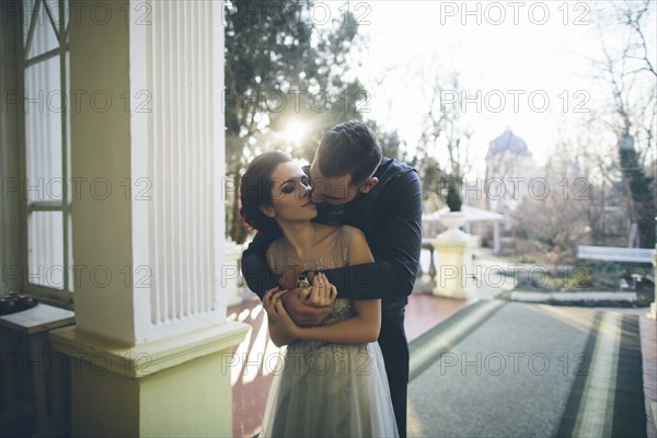 Newlywed couple embracing at terrace